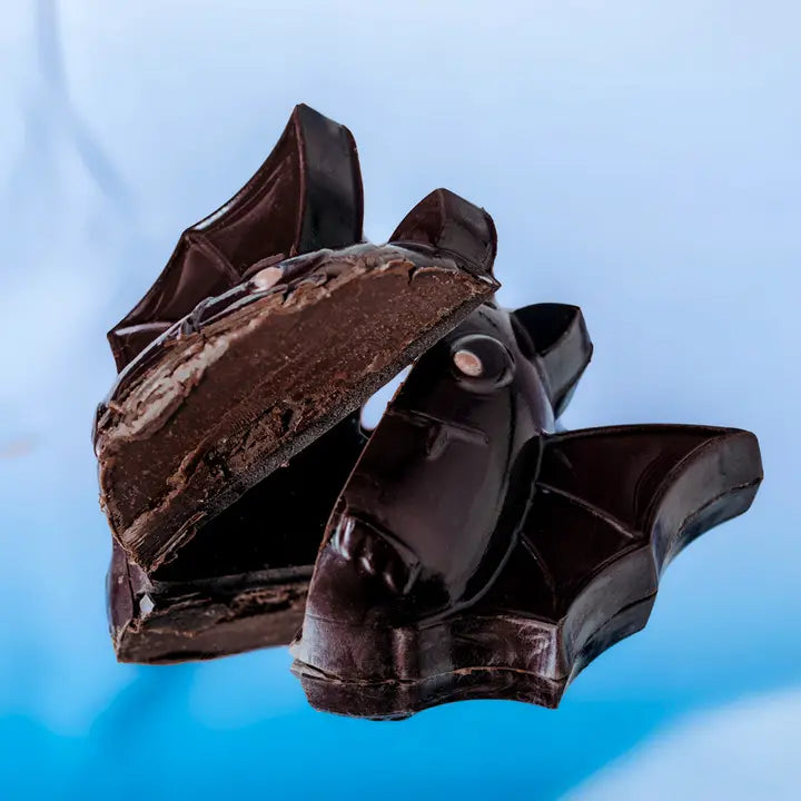 Broken pieces of dark chocolate on a blue background