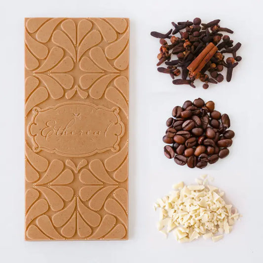 Vegan White Chocolate bar with intricate design, coffee beans, and spices on a white background